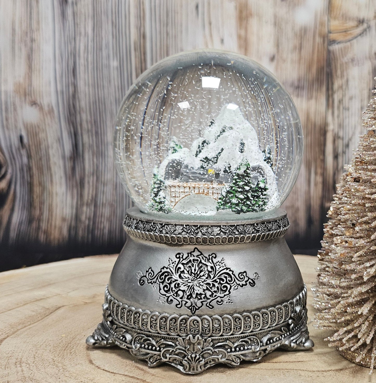 Nostalgische Schneekugel Berglandschaft mit Brücke auf Zinnsockel 100 mm Durchmesser mit Spieluhr - Schneekugelhaus