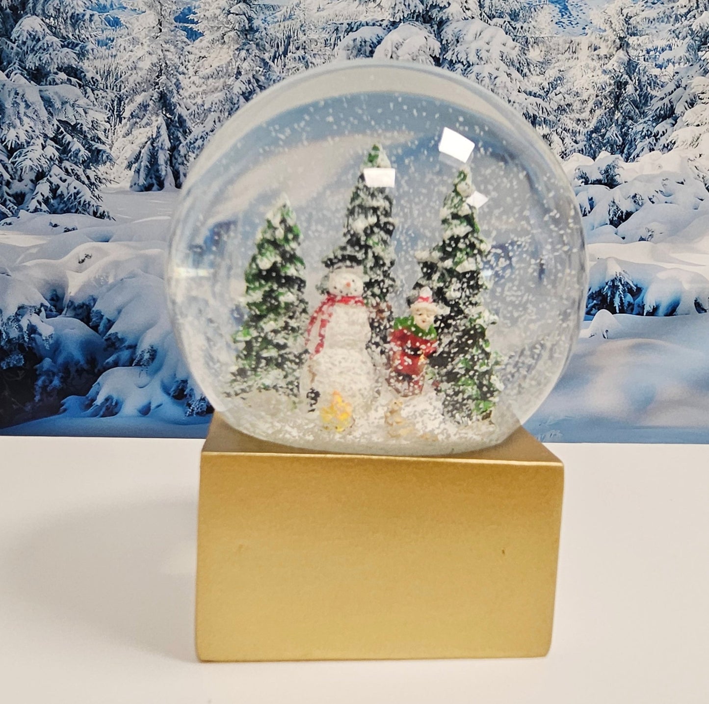 Schneekugel Schneemann steht vor Lagerfeuer auf Sockel golden eckig "PURE - Line" 10 cm Durchmesser - Schneekugelhaus