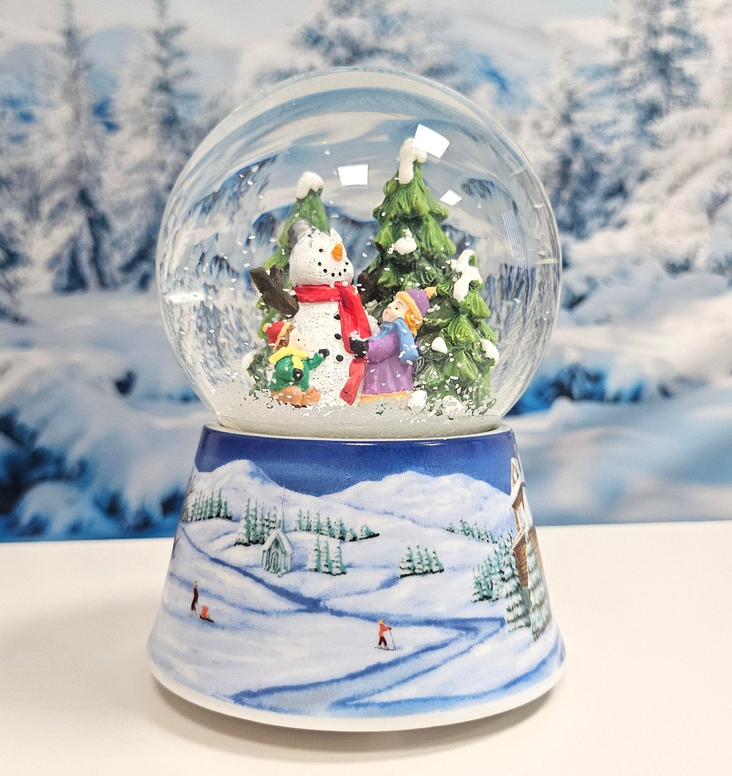 Schneekugel Schneemann zwei Kinder auf Sockel Winterlandschaft mittelblau mit Spieluhr 10 cm Durchmesser - Schneekugelhaus