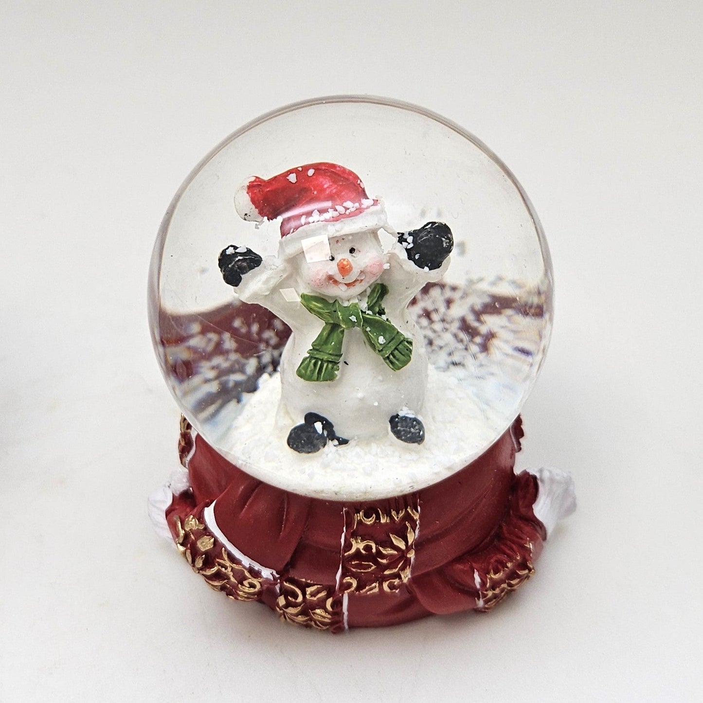 Süße Mini - Schneekugel Schneemann grüner Schal auf Sockel rot gold Winterschal B: 45mm - Schneekugelhaus