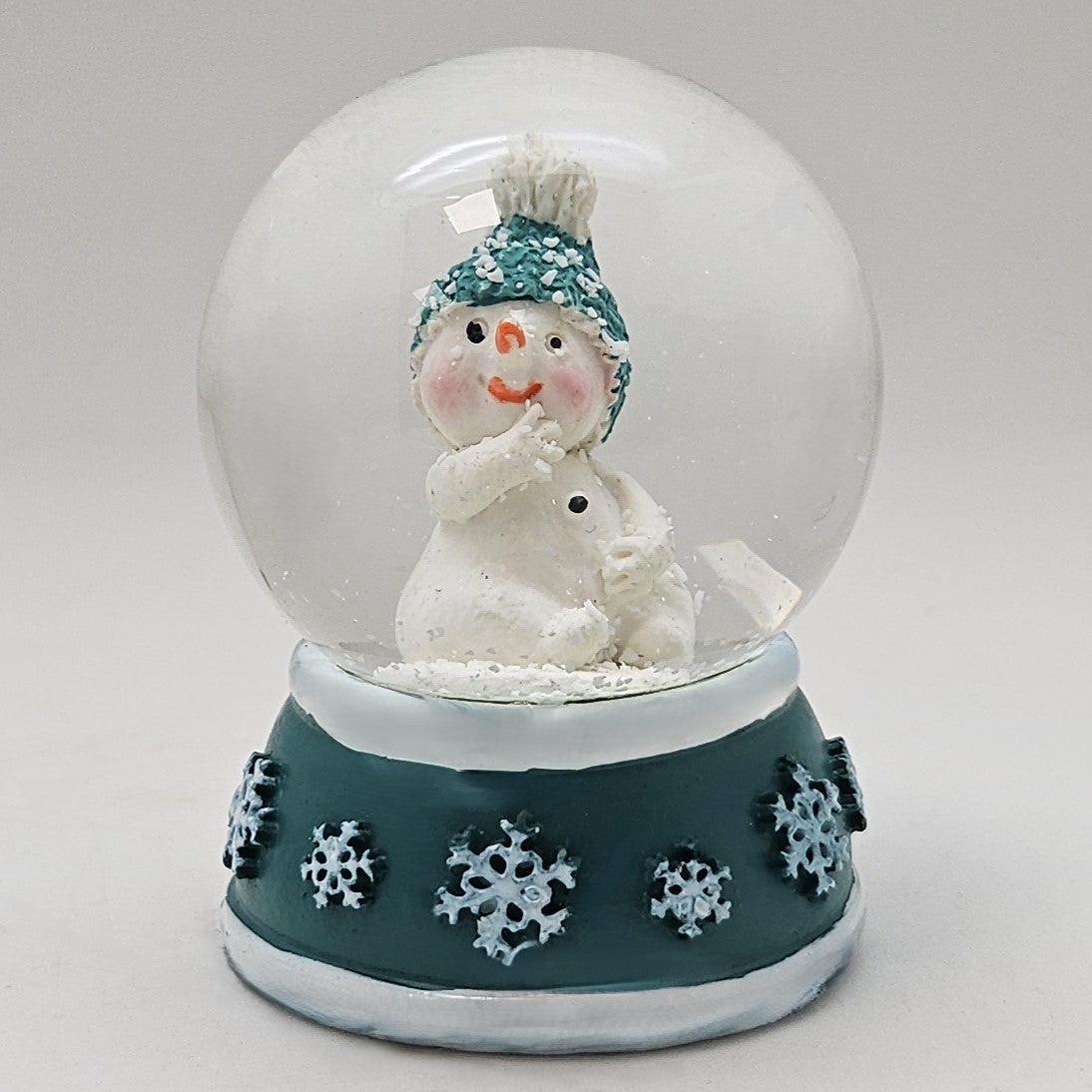 Süße Mini - Schneekugel Schneemann Hand am Mund auf Sockel türkis weiße Schneeeflocke B: 45mm - Schneekugelhaus