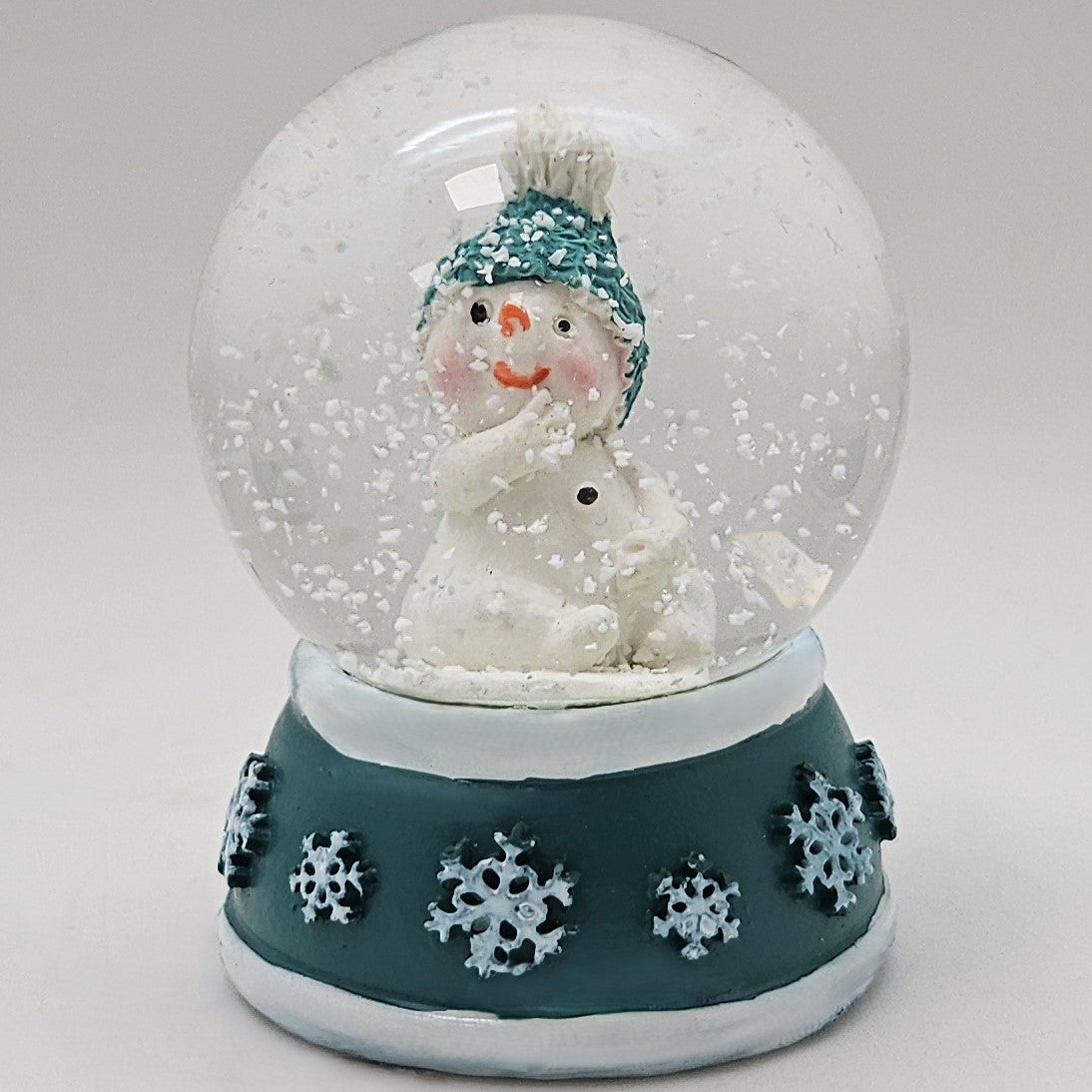 Süße Mini - Schneekugel Schneemann Hand am Mund auf Sockel türkis weiße Schneeeflocke B: 45mm - Schneekugelhaus