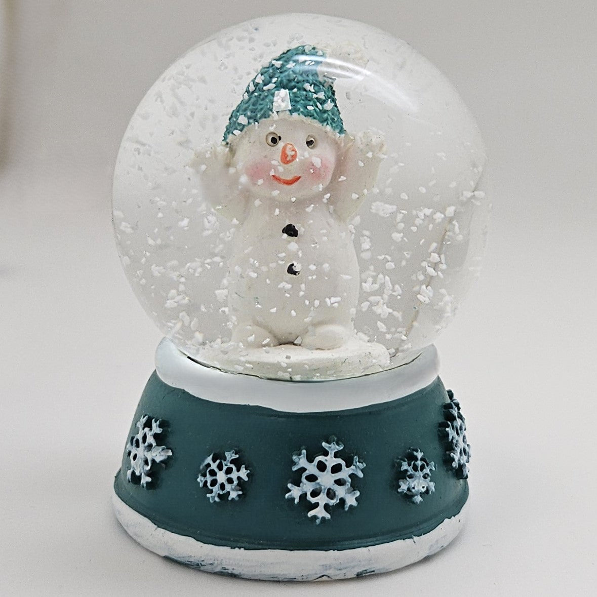 Süße Mini - Schneekugel Schneemann Hände hoch auf Sockel türkis weiße Schneeeflocke B: 45mm - Schneekugelhaus