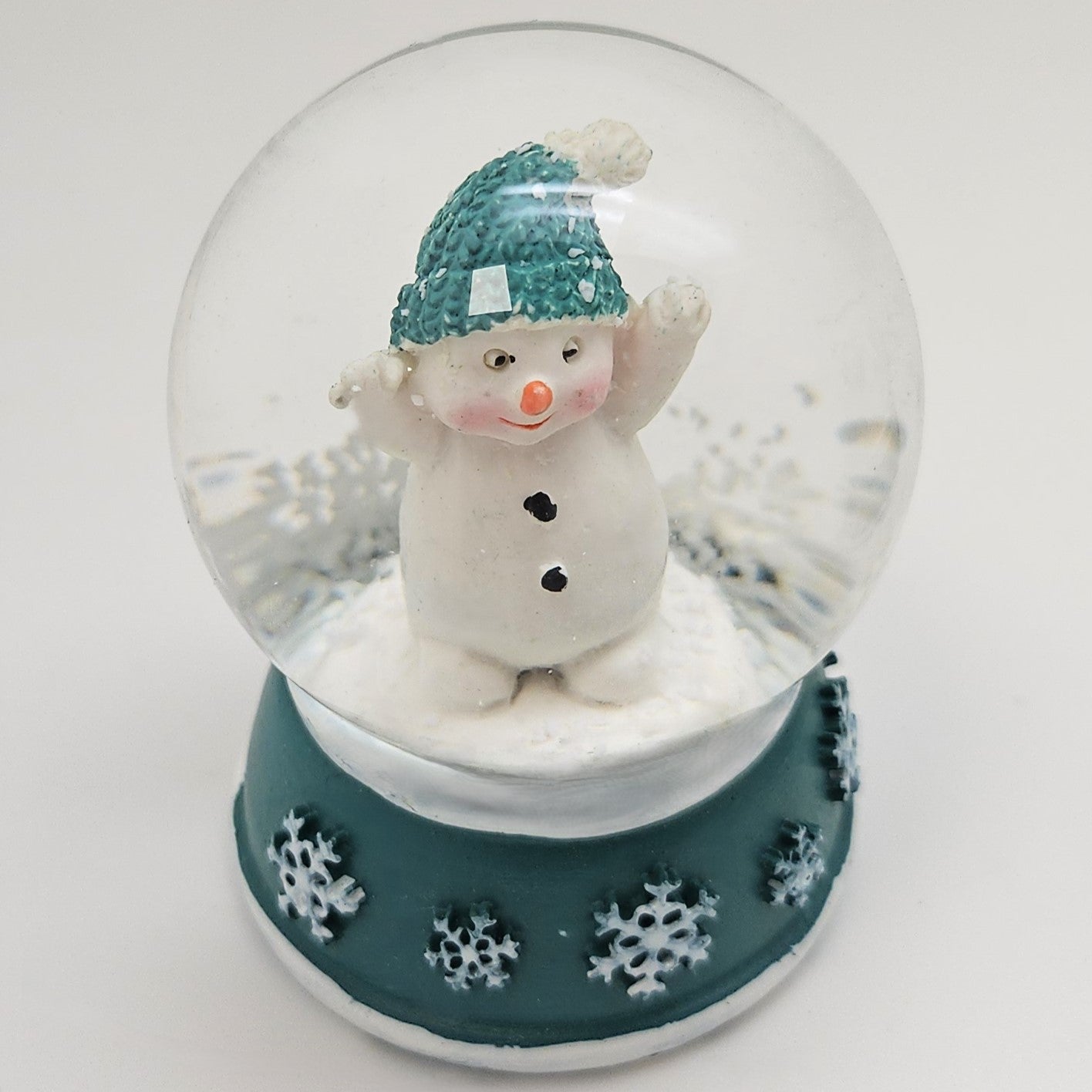 Süße Mini - Schneekugel Schneemann Hände hoch auf Sockel türkis weiße Schneeeflocke B: 45mm - Schneekugelhaus