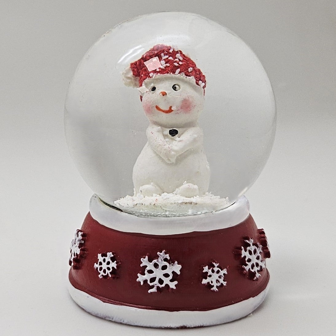 Süße Mini - Schneekugel Schneemann Hände zusammen auf Sockel rot weiße Schneeeflocke B: 45mm - Schneekugelhaus