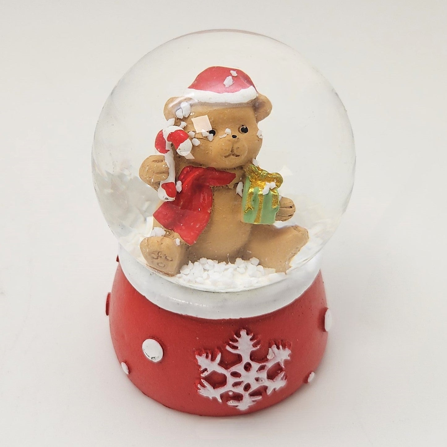 Süße Mini - Schneekugel Weihnachtsteddy auf Sockel rot weiße Schneeeflocke B: 45mm - Schneekugelhaus