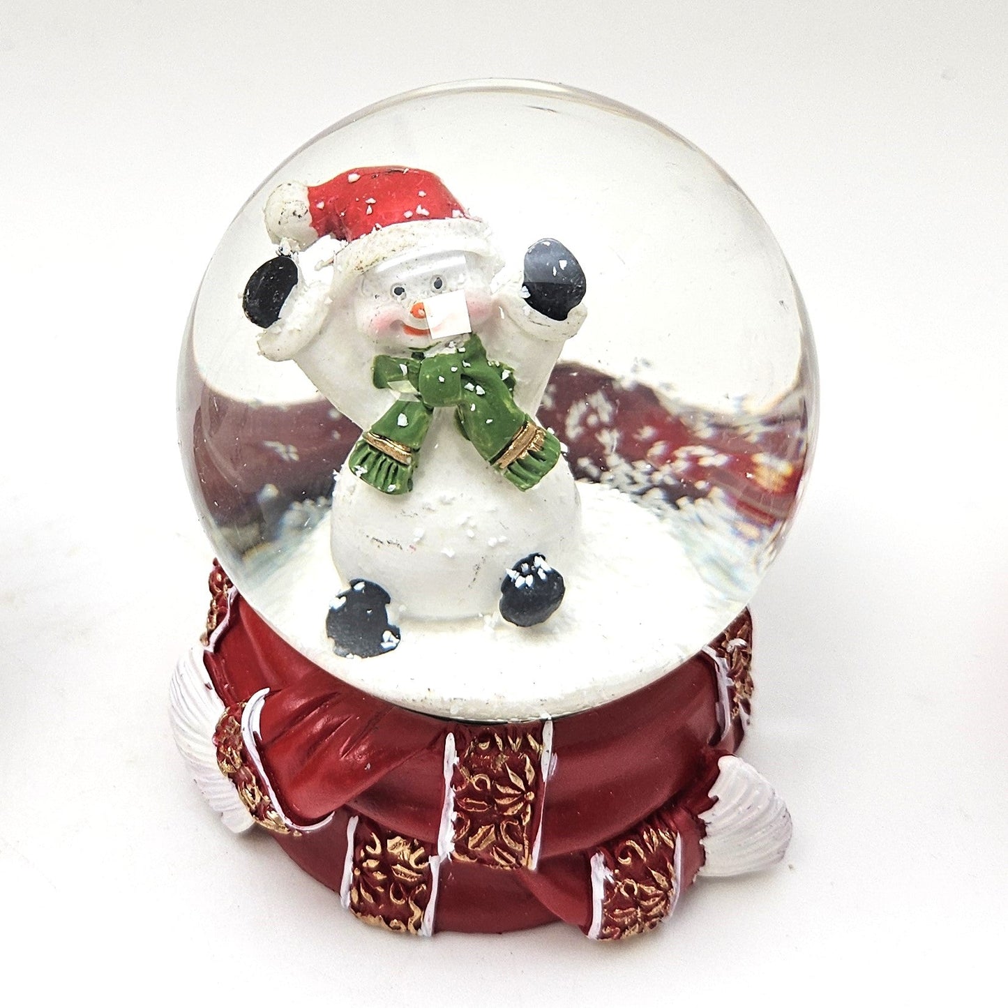 Süße Schneekugel Schneemann grüner Schal auf Sockel rot gold Winterschal B: 65mm - Schneekugelhaus