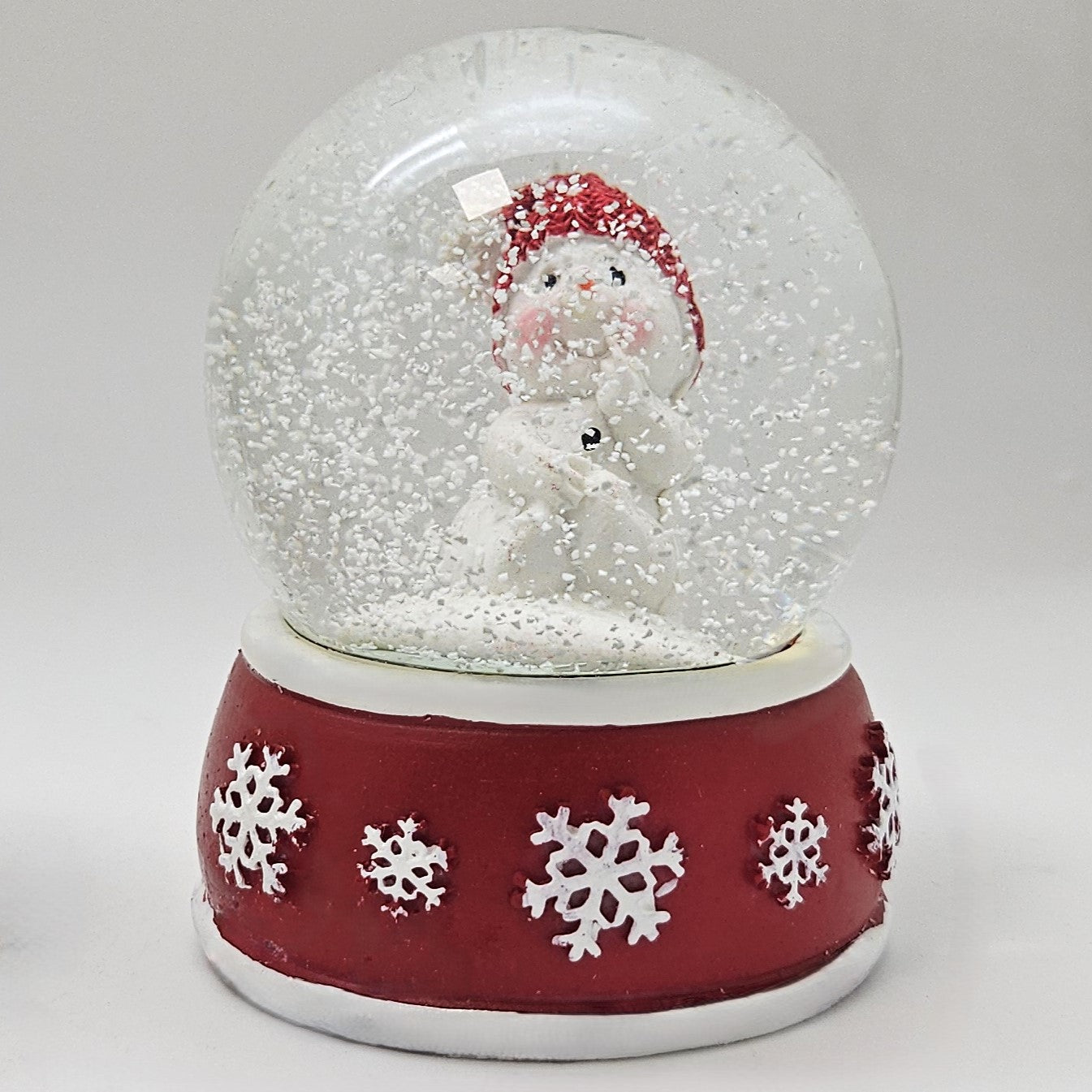 Süße Schneekugel Schneemann Hand am Mund auf Sockel rot weiße Schneeflocke B: 65mm - Schneekugelhaus