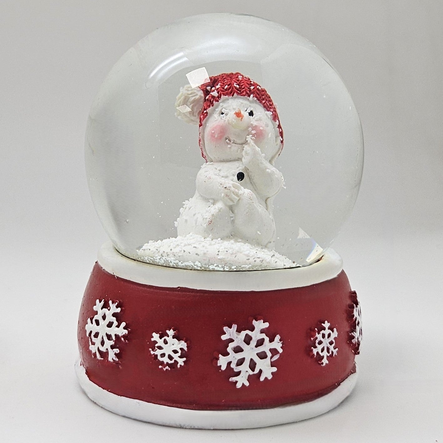 Süße Schneekugel Schneemann Hand am Mund auf Sockel rot weiße Schneeflocke B: 65mm - Schneekugelhaus