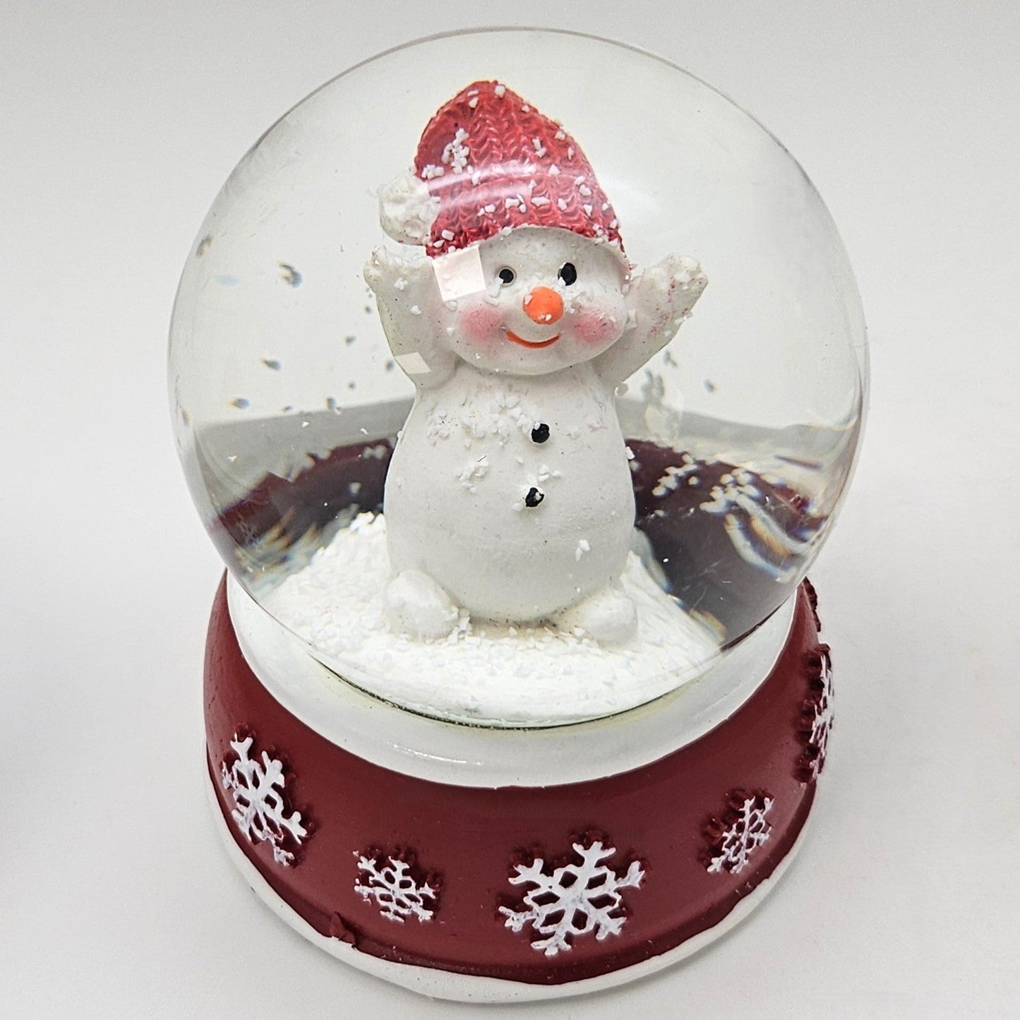 Süße Schneekugel Schneemann Hände hoch auf Sockel rot weiße Schneeflocke B: 65mm - Schneekugelhaus