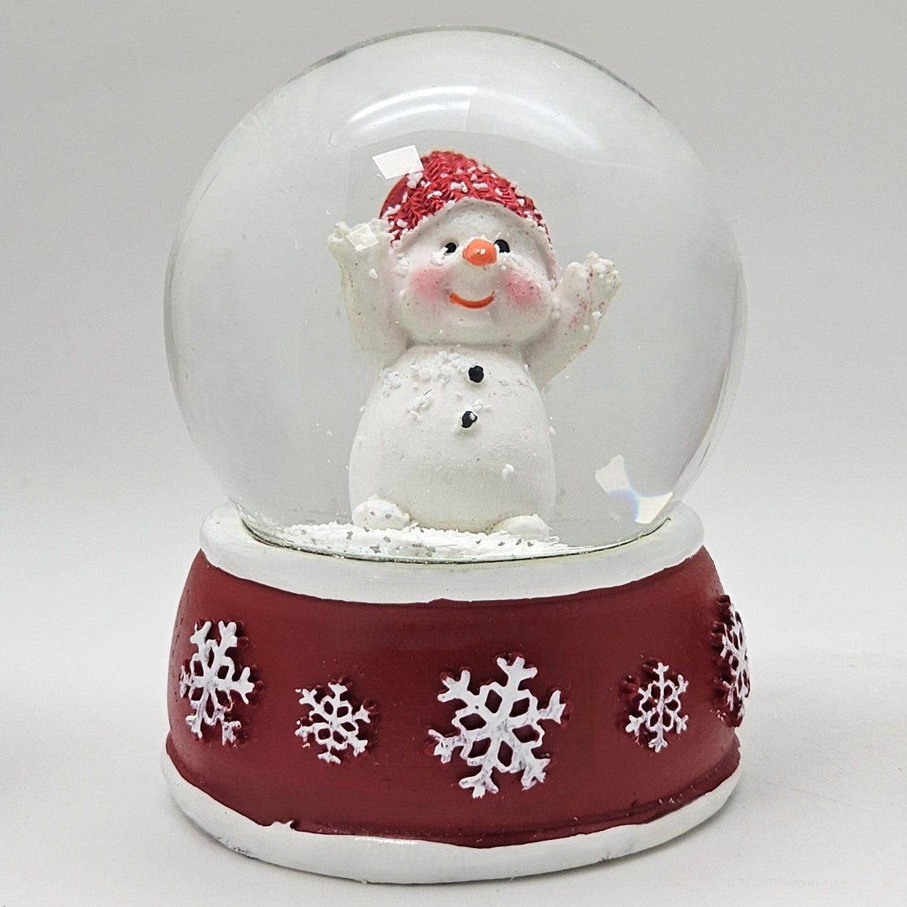 Süße Schneekugel Schneemann Hände hoch auf Sockel rot weiße Schneeflocke B: 65mm - Schneekugelhaus
