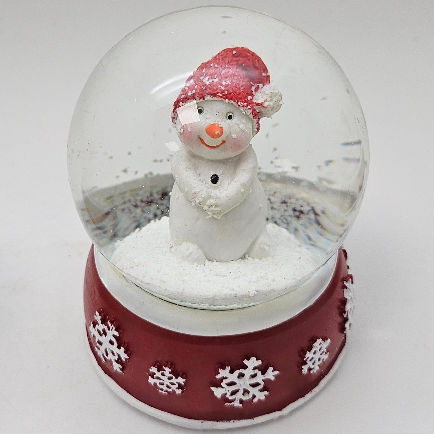 Süße Schneekugel Schneemann Hände zusammen auf Sockel rot weiße Schneeflocke B: 65mm - Schneekugelhaus