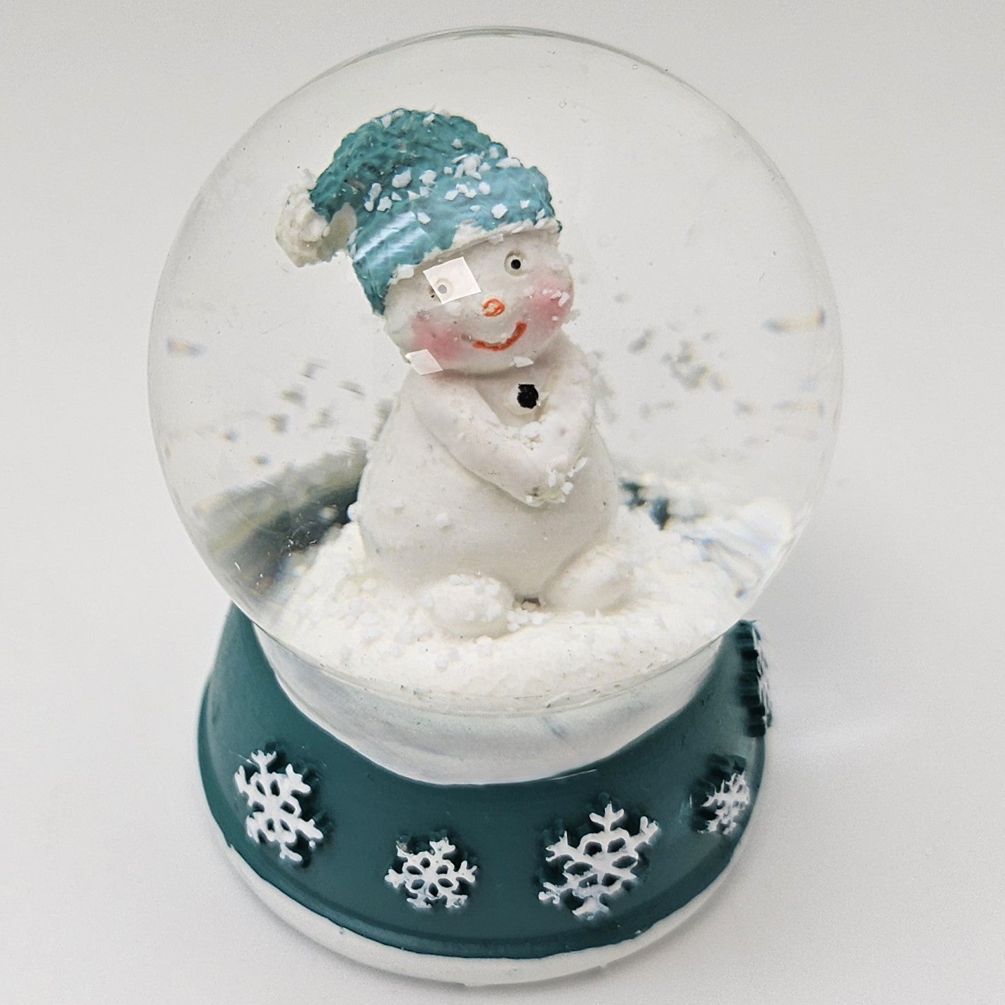 Süße Schneekugel Schneemann Hände zusammen auf Sockel türkis weiße Schneeflocke B: 65mm - Schneekugelhaus