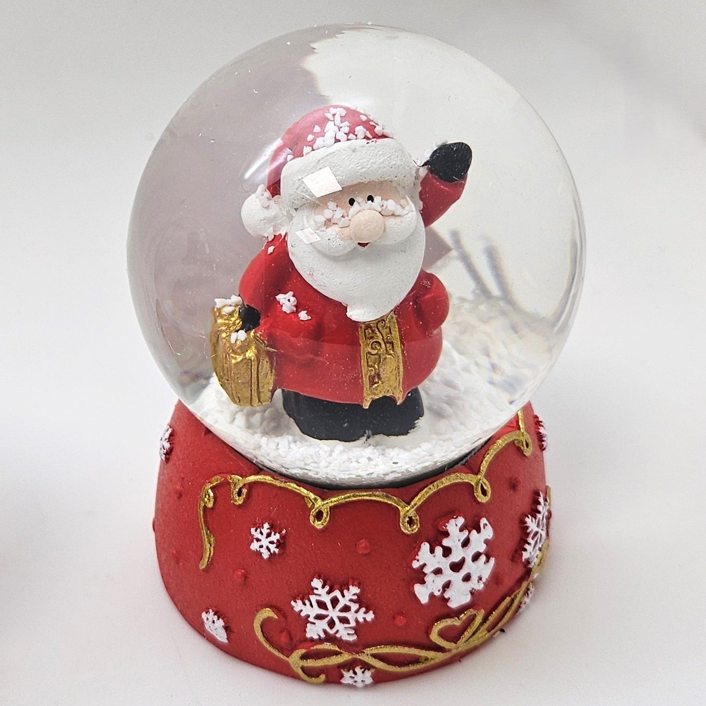 Süße Schneekugel Weihnachtsmann auf Sockel rot weiße Schneeflocke B: 65mm - Schneekugelhaus