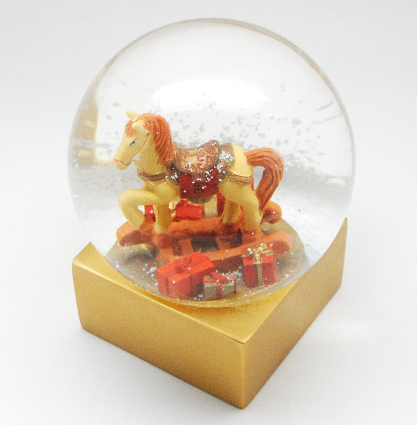 Designer Schneekugel Schaukelpferd mit Geschenken rot gold Sockel gold eck PURE-Line 12 cm Durchmesser - Schneekugelhaus