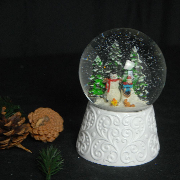 Edle Schneekugel Schneemann vor Lagerfeuer auf weißem Ornamentsockel 100 mm Durchmesser mit Spieluhr