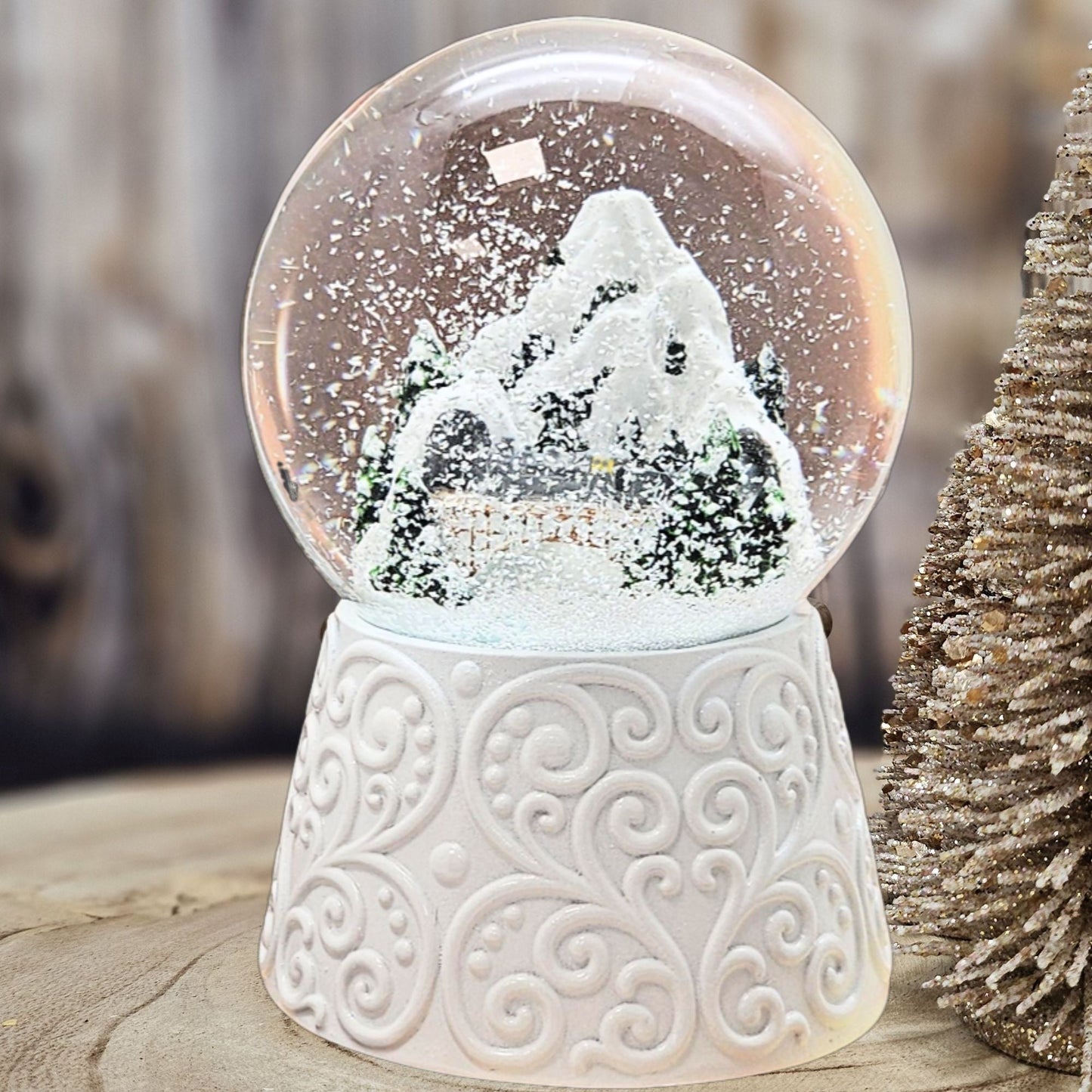 Nostalgische Schneekugel Berglandschaft mit Brücke auf Sockel weiß Ornamente 100 mm Durchmesser mit Spieluhr - Schneekugelhaus