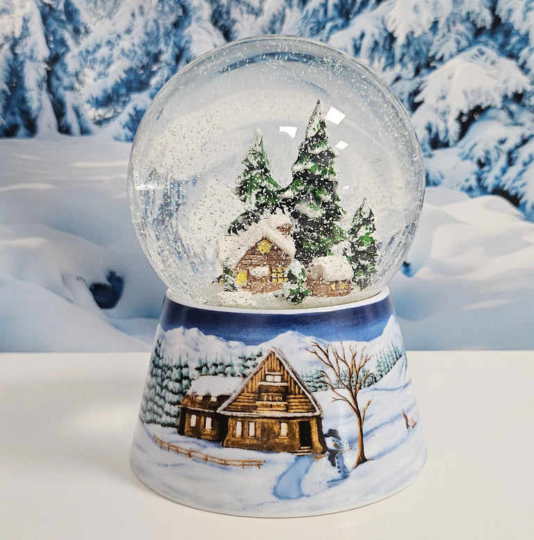 Nostalgische Schneekugel Verschneite Winterhütte auf Winterlandschaft mittelblau 100 mm Durchmesser mit Spieluhr - Schneekugelhaus