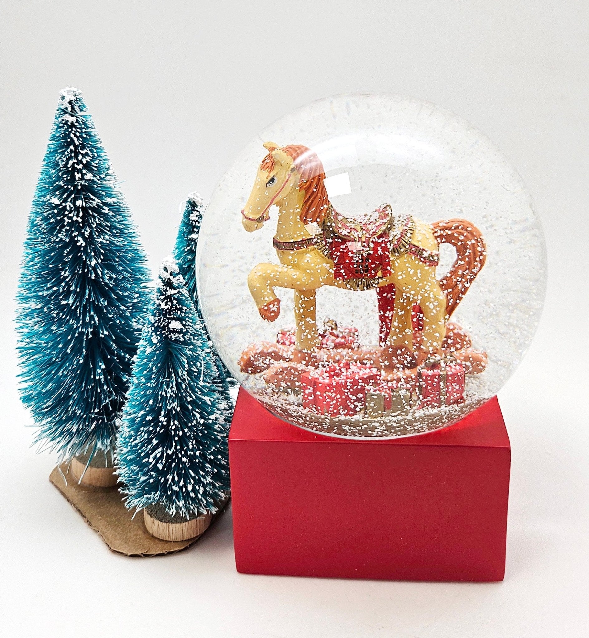 Schneekugel Schaukelpferd mit Geschenken rot eck "PURE - Line" 10 cm Durchmesser - Schneekugelhaus