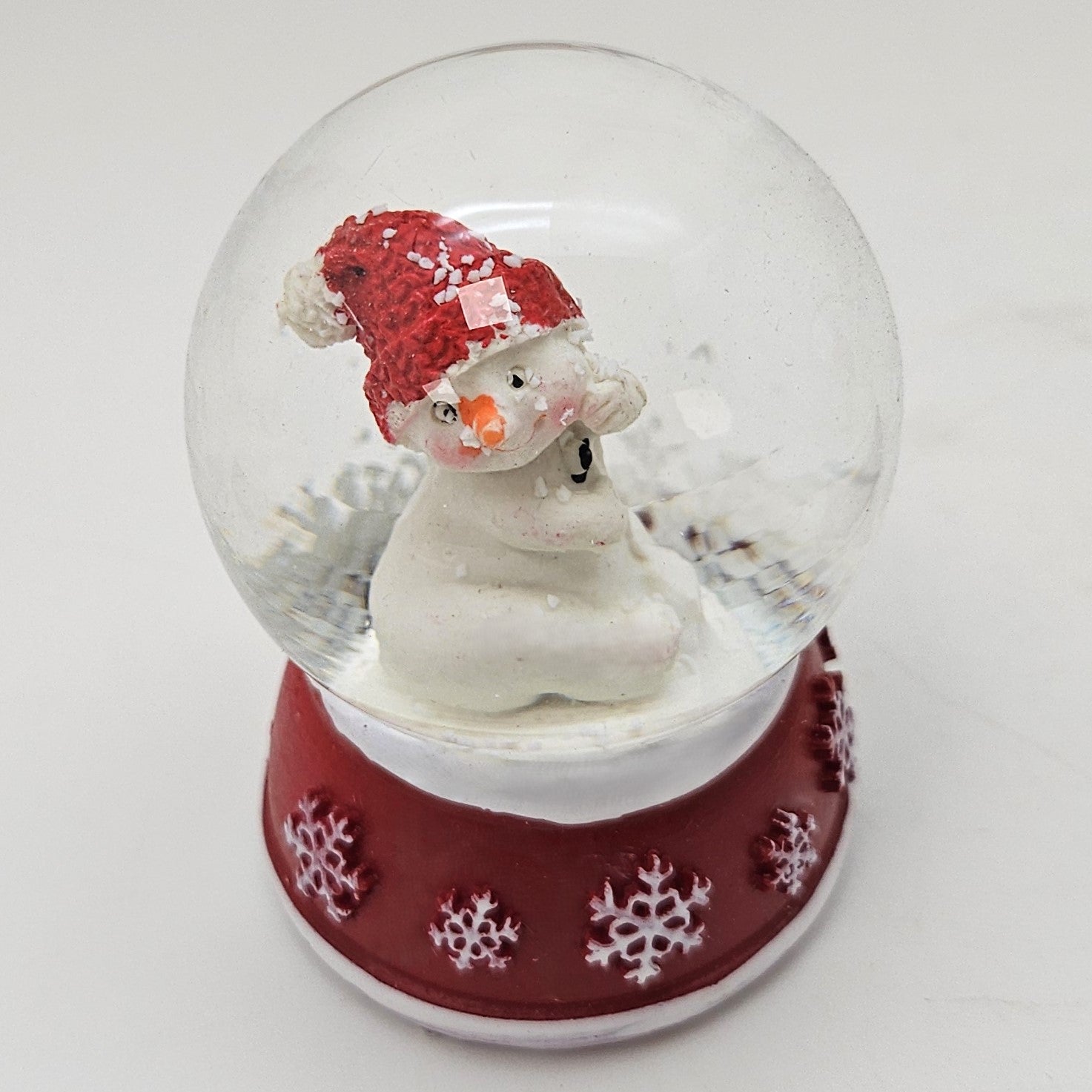 Süße Mini - Schneekugel Schneemann dreht sich auf Sockel rot weiße Schneeeflocke B: 45mm - Schneekugelhaus