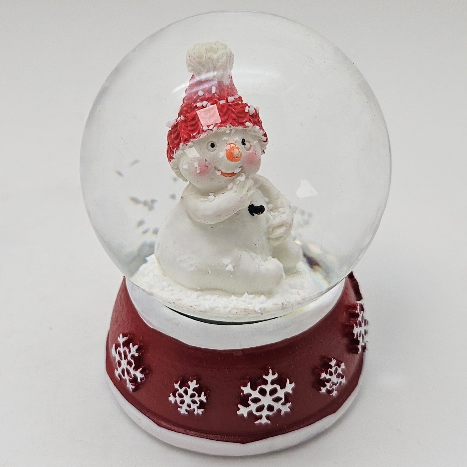 Süße Mini - Schneekugel Schneemann Hand am Mund auf Sockel rot weiße Schneeeflocke B: 45mm - Schneekugelhaus