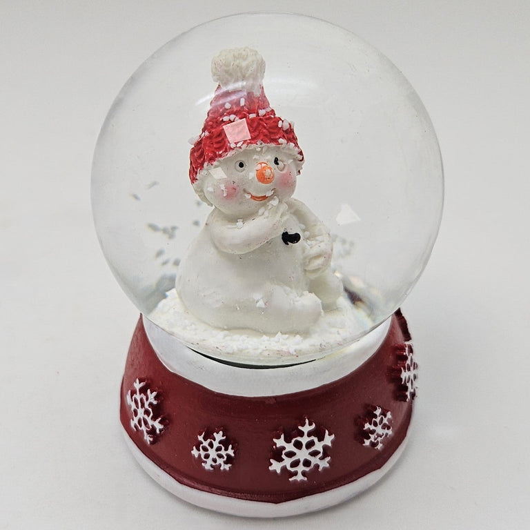 Süße Mini - Schneekugel Schneemann Hand am Mund auf Sockel rot weiße Schneeeflocke B: 45mm - Schneekugelhaus