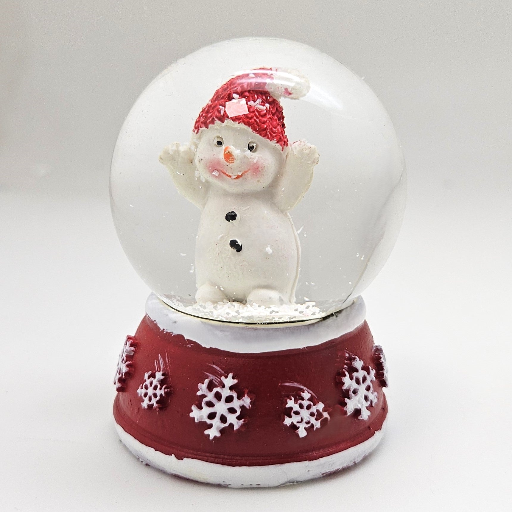 Süße Mini - Schneekugel Schneemann Hände hoch auf Sockel rot weiße Schneeeflocke B: 45mm - Schneekugelhaus