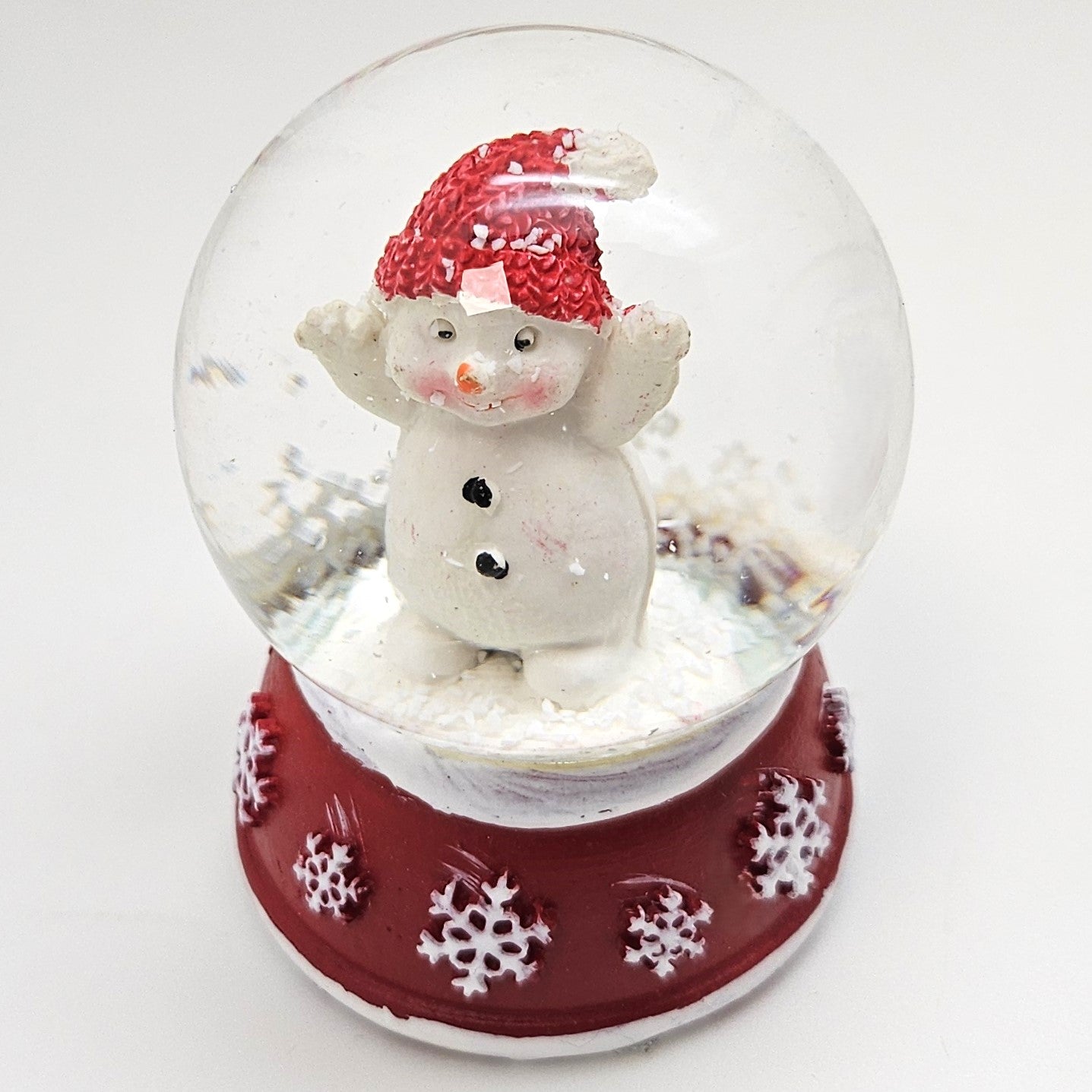 Süße Mini - Schneekugel Schneemann Hände hoch auf Sockel rot weiße Schneeeflocke B: 45mm - Schneekugelhaus
