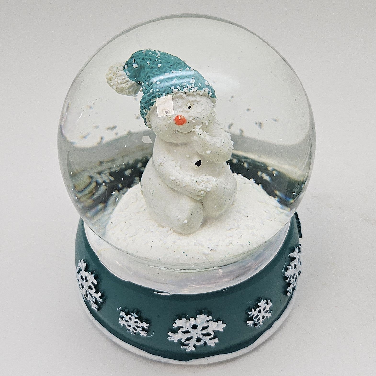 Süße Schneekugel Schneemann Hand am Mund auf Sockel türkis weiße Schneeflocke B: 65mm - Schneekugelhaus