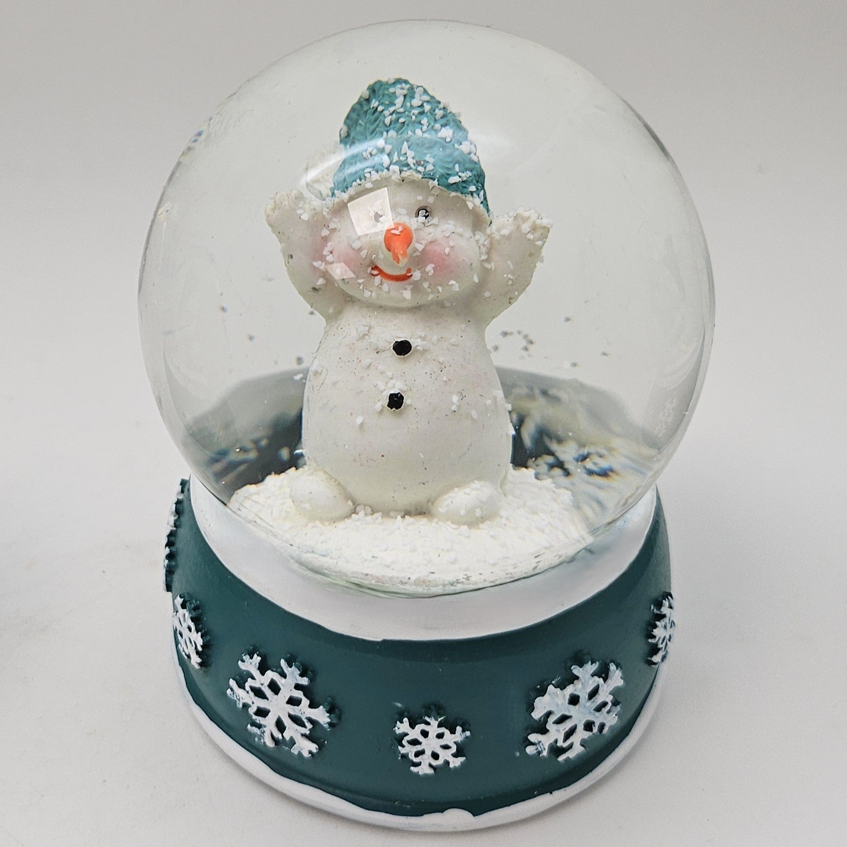 Süße Schneekugel Schneemann Hände hoch auf Sockel türkis weiße Schneeflocke B: 65mm - Schneekugelhaus