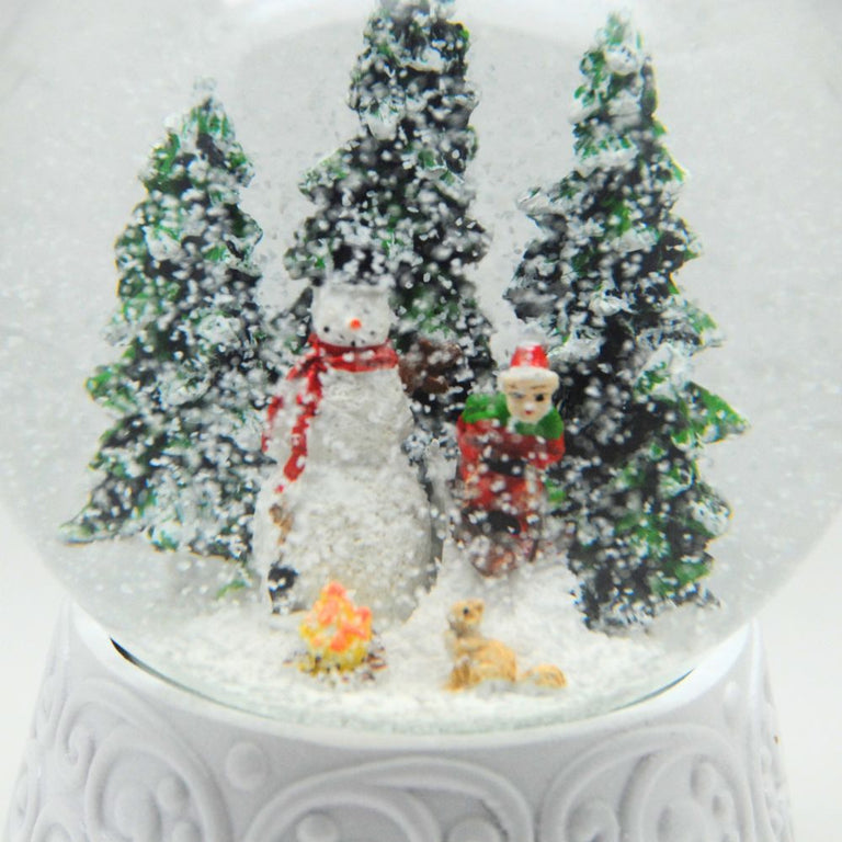 Edle Schneekugel Schneemann vor Lagerfeuer auf weißem Ornamentsockel 100 mm Durchmesser mit Spieluhr - Schneekugelhaus