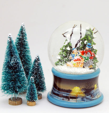 Schneekugel Familie im Winterwald mit Schlitten auf Sockel Winterlandschaft Eisläufer blau mit Spieluhr - Schneekugelhaus