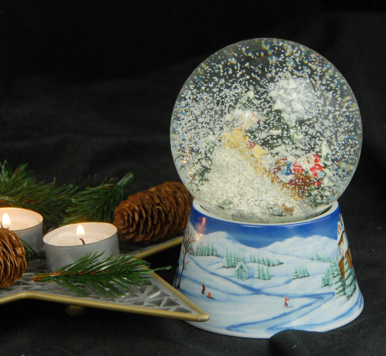 Schneekugel Santa im Schlitten auf Sockel Winterlandschaft mittelblau mit Spieluhr 10 cm Durchmesser - Schneekugelhaus