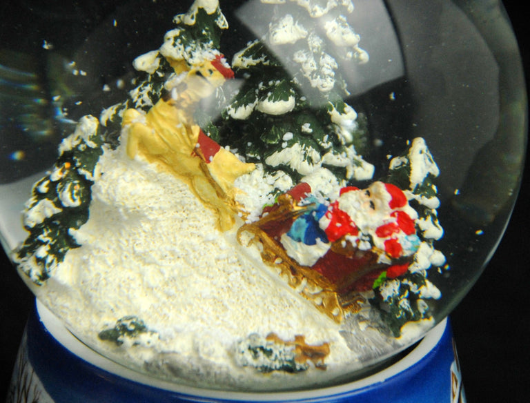 Schneekugel Santa im Schlitten auf Sockel Winterlandschaft mittelblau mit Spieluhr 10 cm Durchmesser - Schneekugelhaus