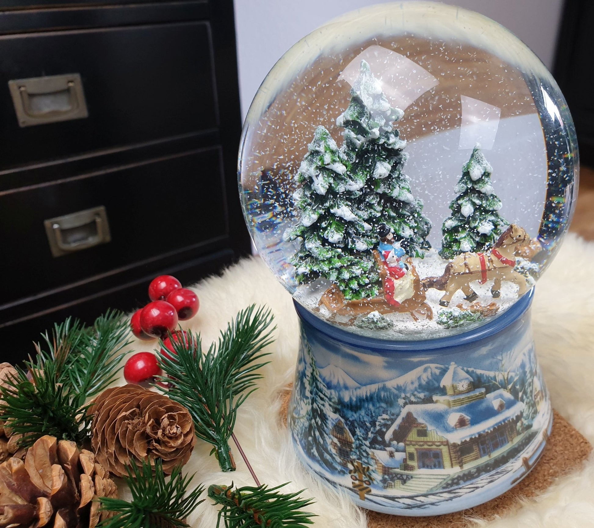 Schneekugel Schlittenfahrt auf Sockel Winterlandschaft mit Spieluhr 10 cm Durchmesser - Schneekugelhaus
