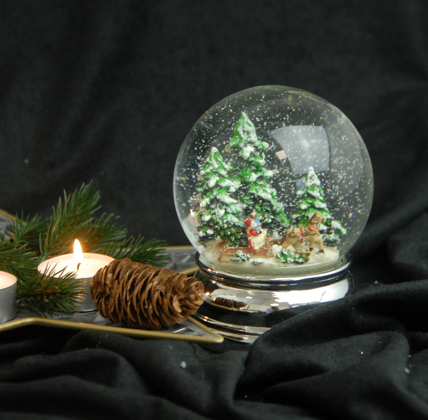 Schneekugel Schlittenfahrt Christbaum holen auf Sockel silber rund geschwungen 10 cm Durchmesser - Schneekugelhaus