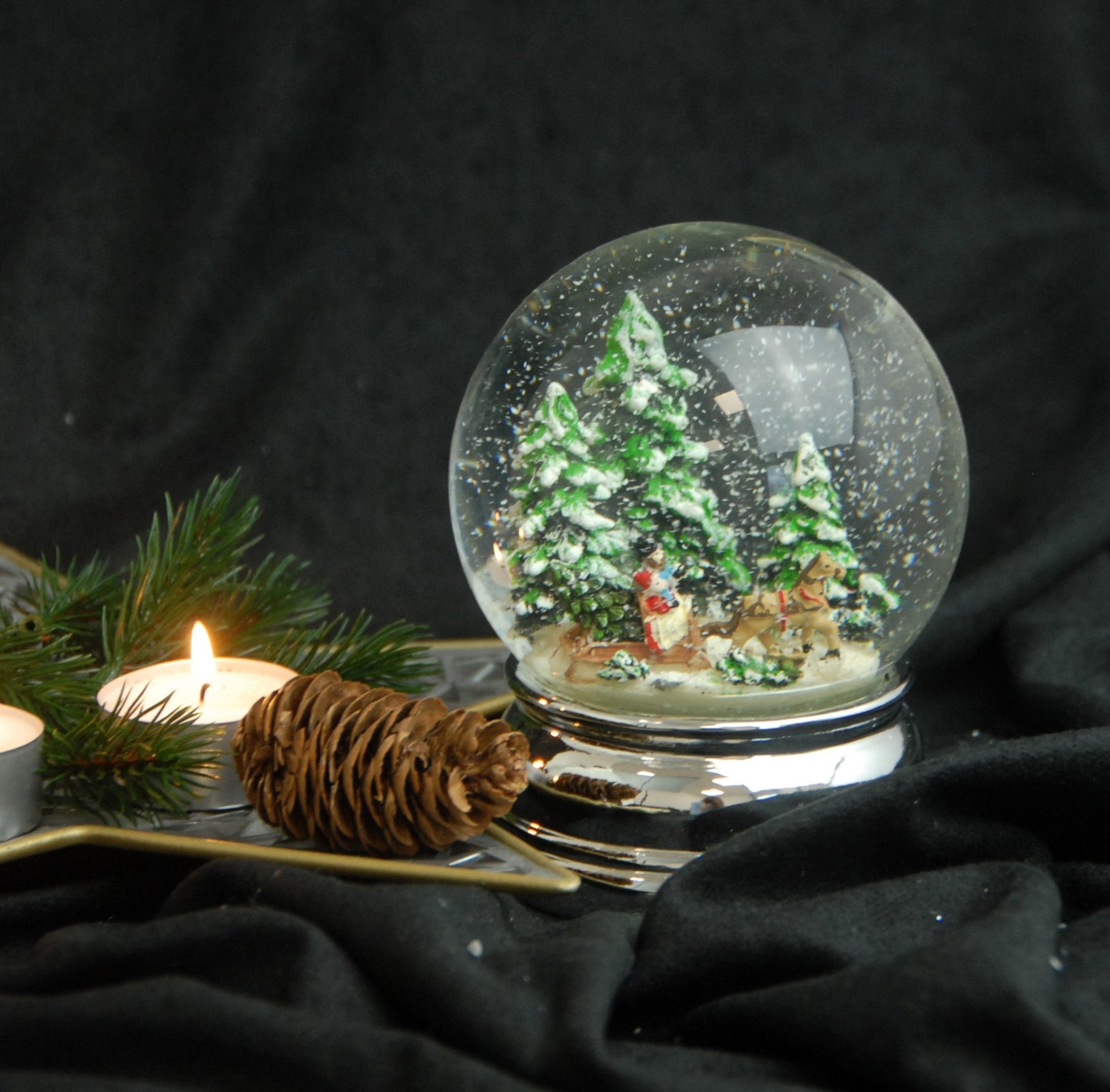 Schneekugel Schlittenfahrt Christbaum holen auf Sockel silber rund geschwungen 10 cm Durchmesser - Schneekugelhaus