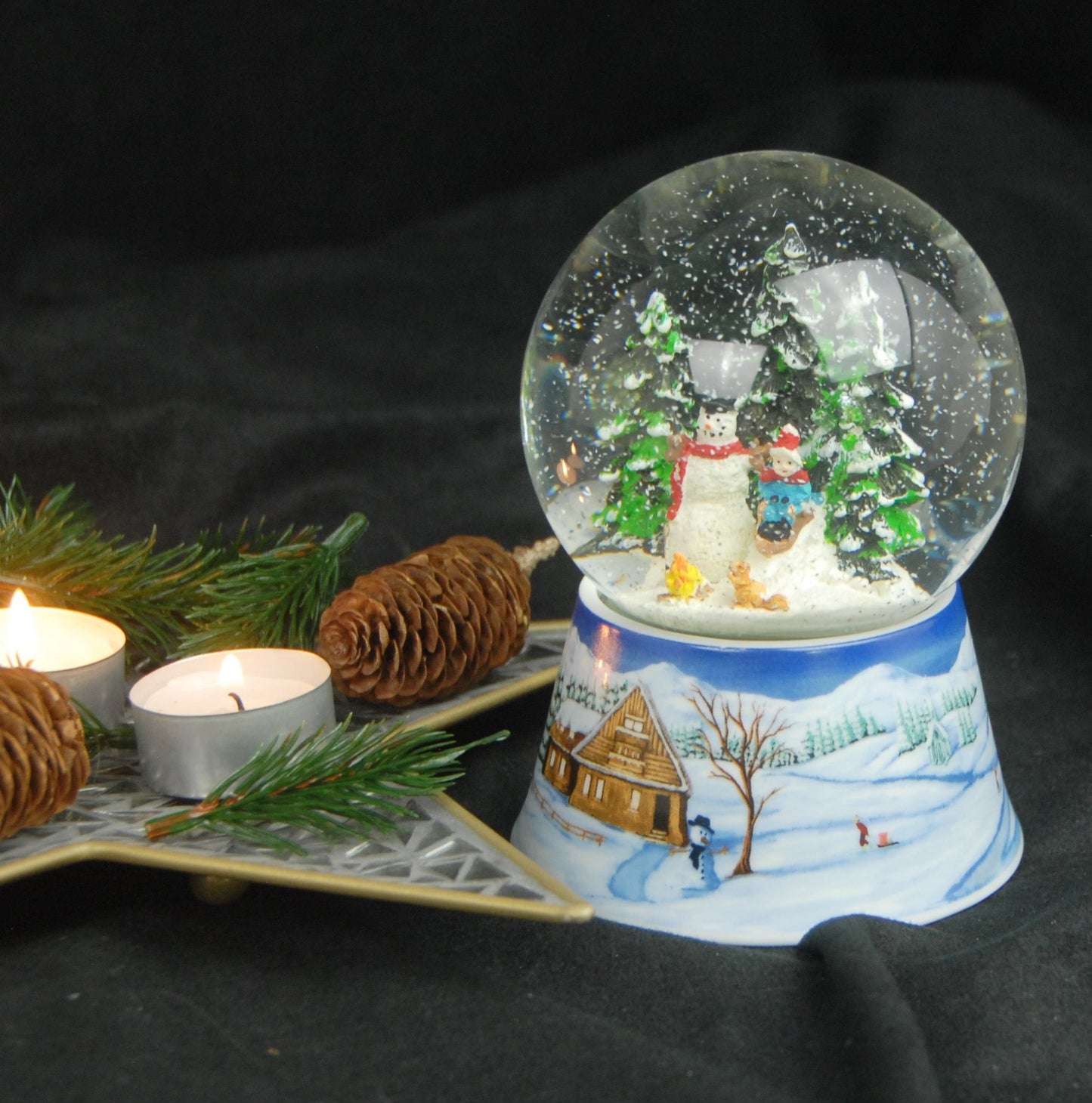 Schneekugel Schneemann bauen mit Lagerfeuer auf Sockel Winterlandschaft mit Spieluhr 10 cm Durchmesser - Schneekugelhaus