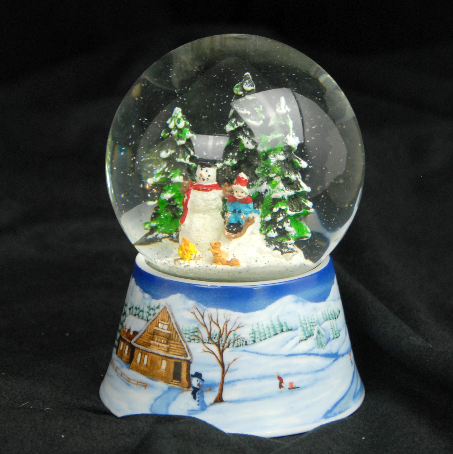 Schneekugel Schneemann bauen mit Lagerfeuer auf Sockel Winterlandschaft mit Spieluhr 10 cm Durchmesser - Schneekugelhaus