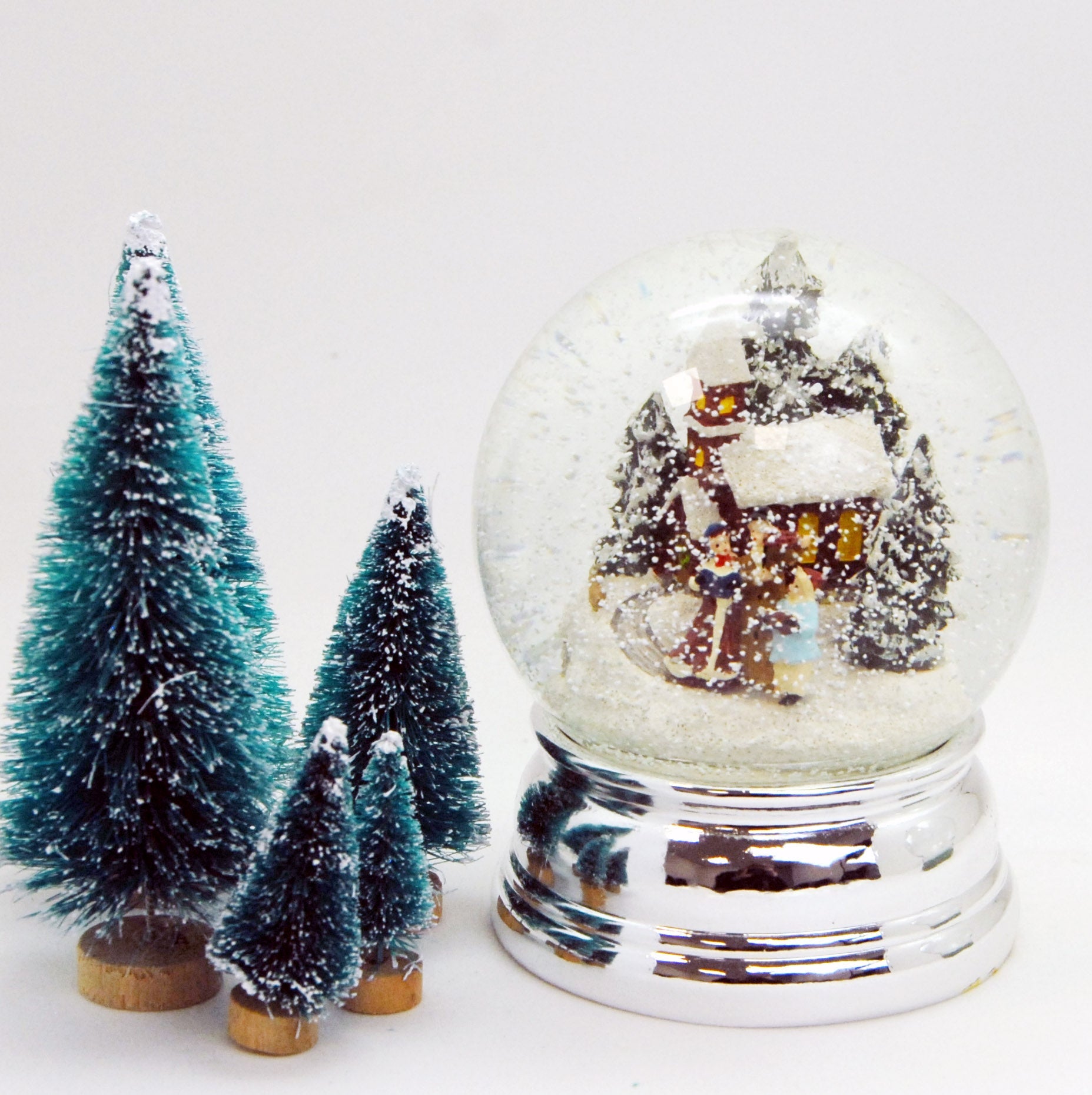 Schneekugel Weihnachtsspaziergang silber auf Sockel silber rund geschwungen 10 cm Durchmesser - Schneekugelhaus